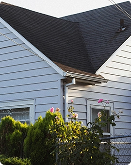 white house with black roof and roses