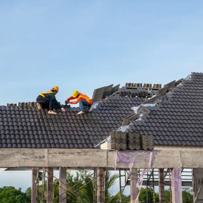 Professional roofers installing concrete tile roofing on new construction home in Hayward California